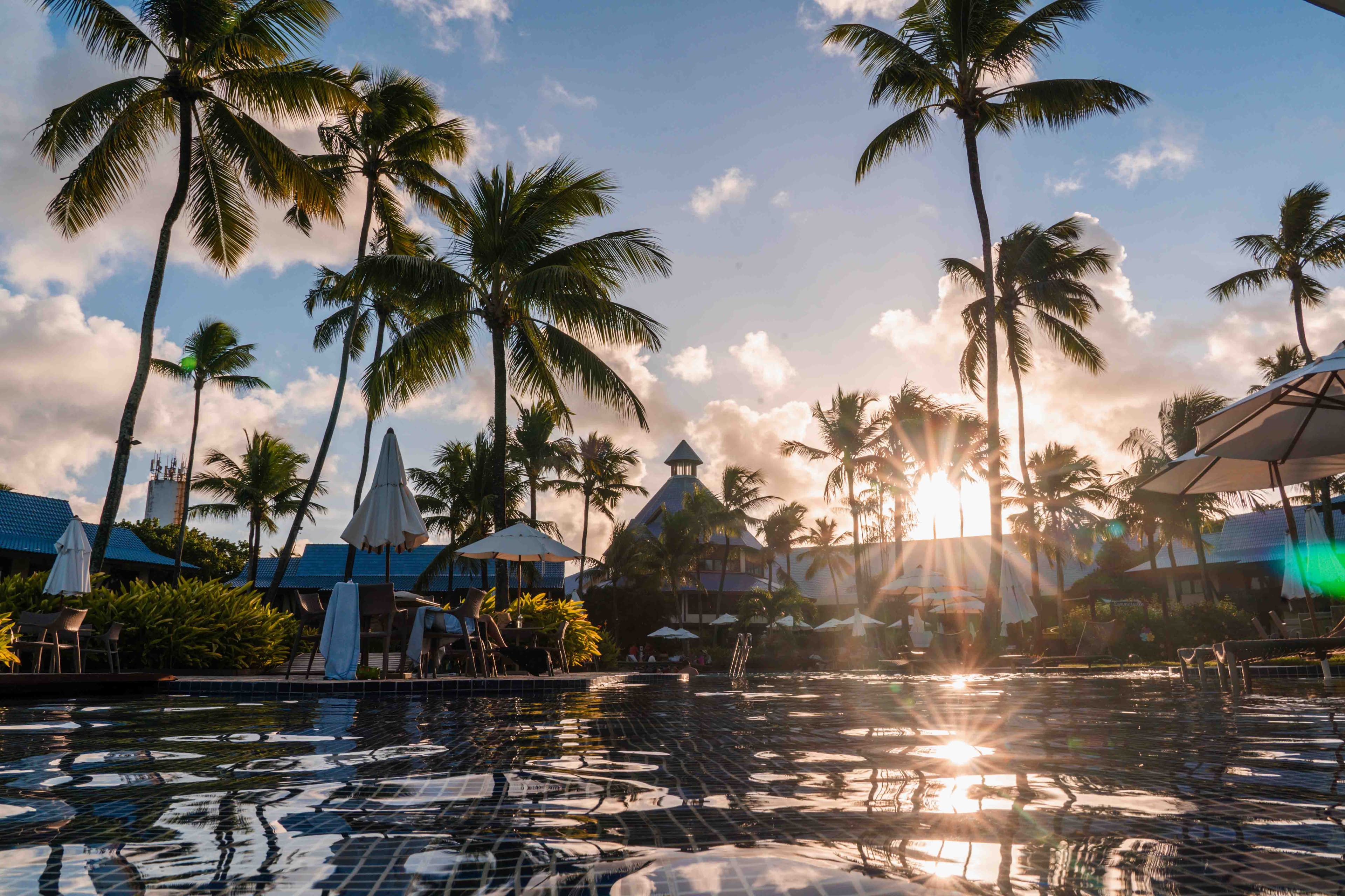 Piscina de borda infinita com vista para o mar ao entardecer, em uma hospedagem selecionada pela curadoria do Veperia